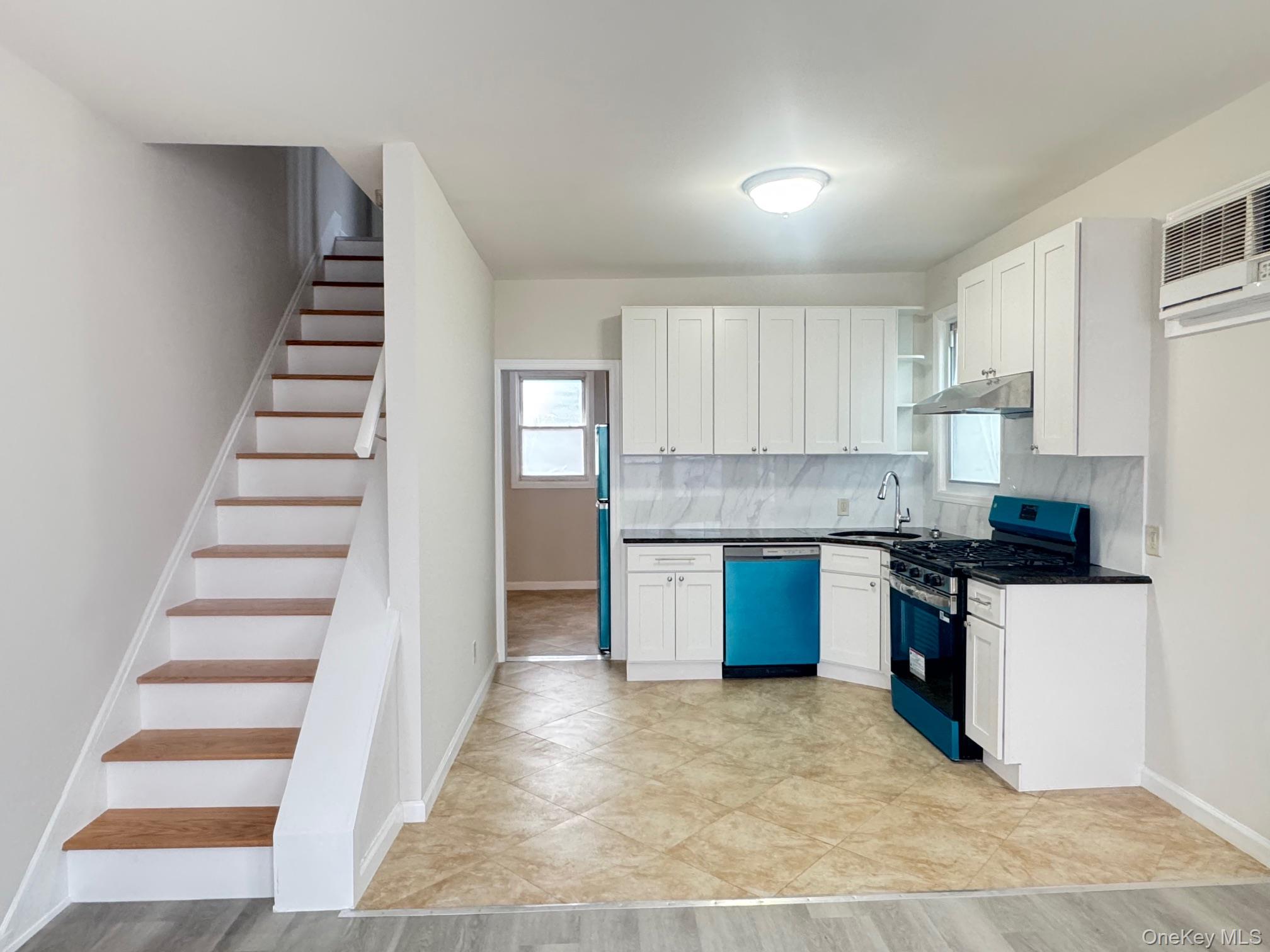164-36 77th Road Queens, NY 11366 - Photo 2 of 20 a kitchen with granite countertop a stove and a sink