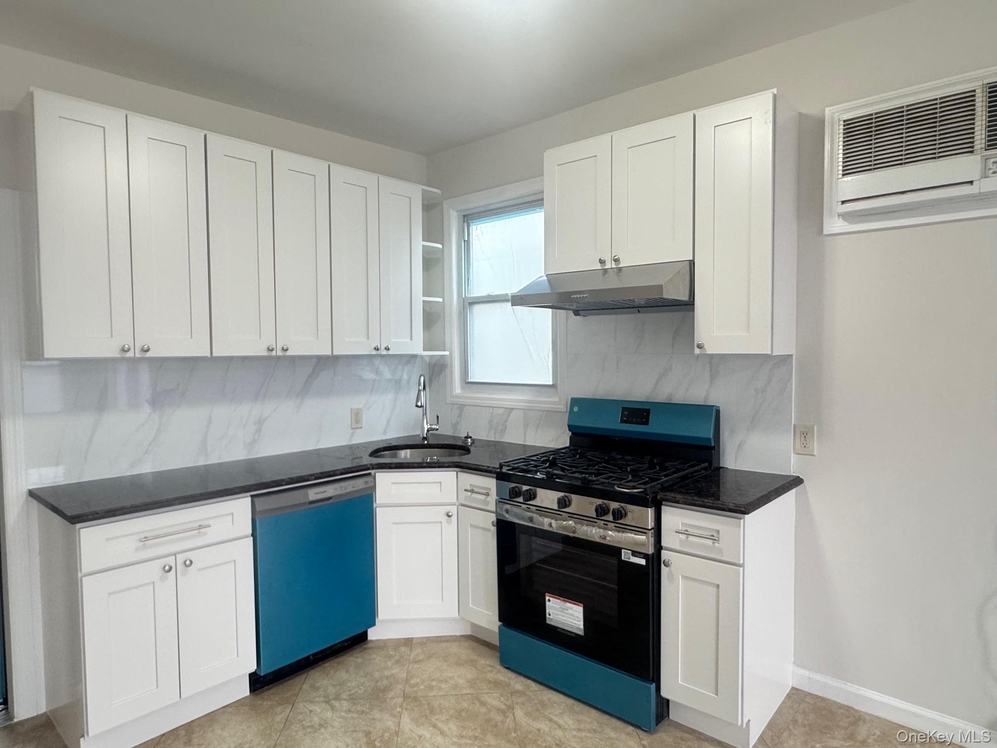 164-36 77th Road Queens, NY 11366 - Photo 3 of 20 a kitchen with granite countertop white cabinets and stainless steel appliances