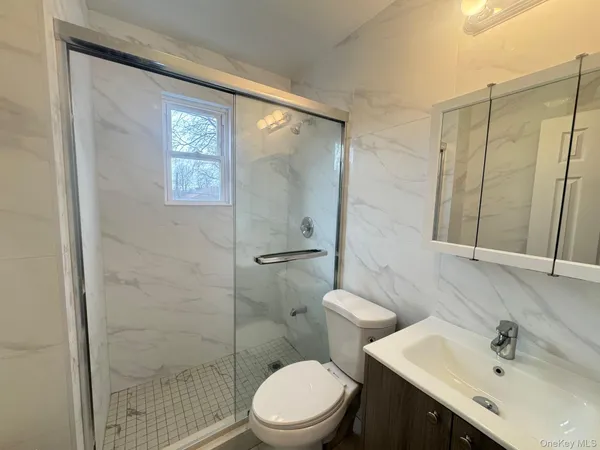 a bathroom with a sink a toilet and shower