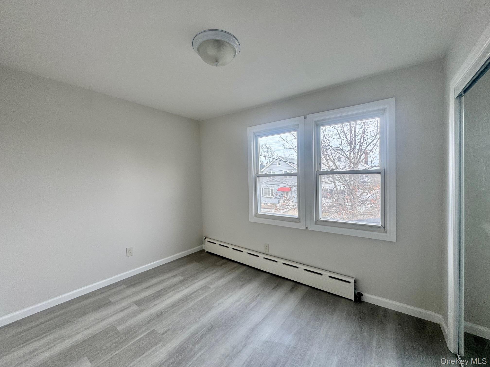 164-36 77th Road Queens, NY 11366 - Photo 9 of 20 an empty room with a window