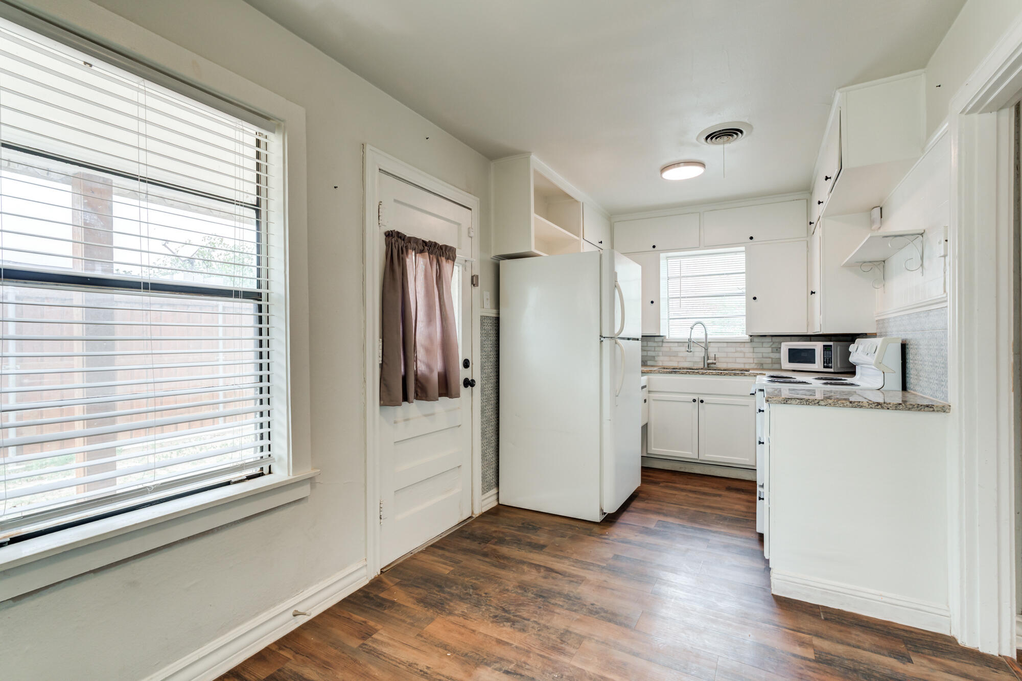 2308 30th Street Lubbock, TX 79411 - Photo 10 of 21 a kitchen with white cabinets and white appliances