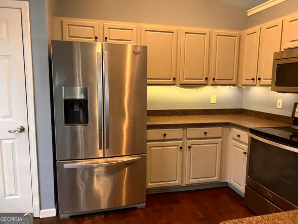 a kitchen with appliances a sink and cabinets