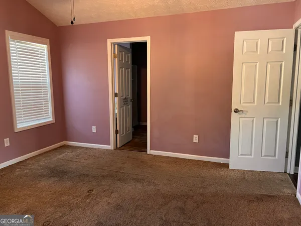an empty room with windows and closet