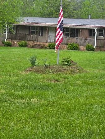 a front view of a house with a yard and green space