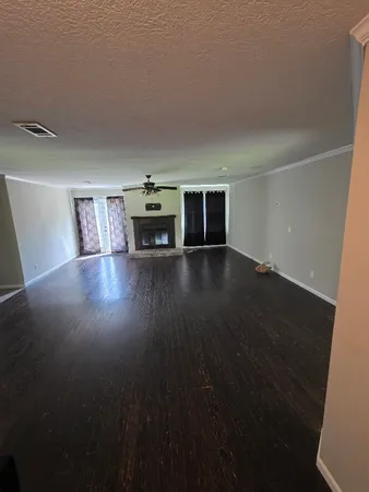 a view of empty room with wooden floor and fireplace