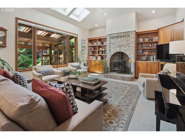 a living room with furniture fireplace and a large window