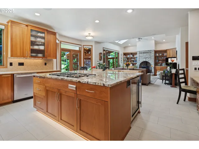 a dining hall with stainless steel appliances granite countertop a sink and a refrigerator