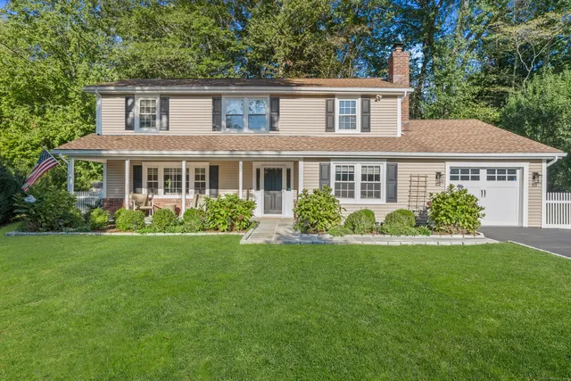a front view of a house with a yard and trees
