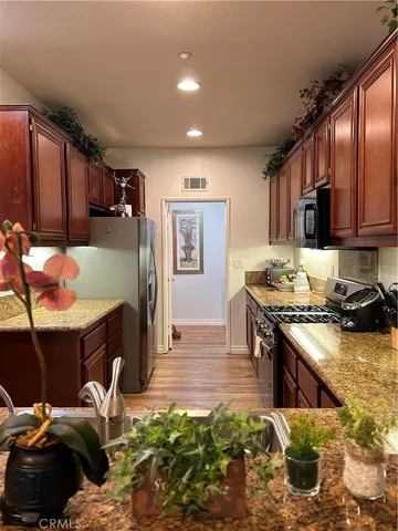 a kitchen with kitchen island granite countertop a stove and cabinets