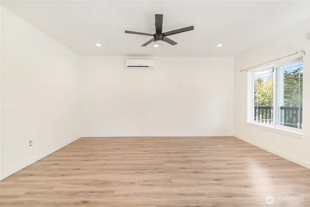 a view of a room with wooden floor and a ceiling fan
