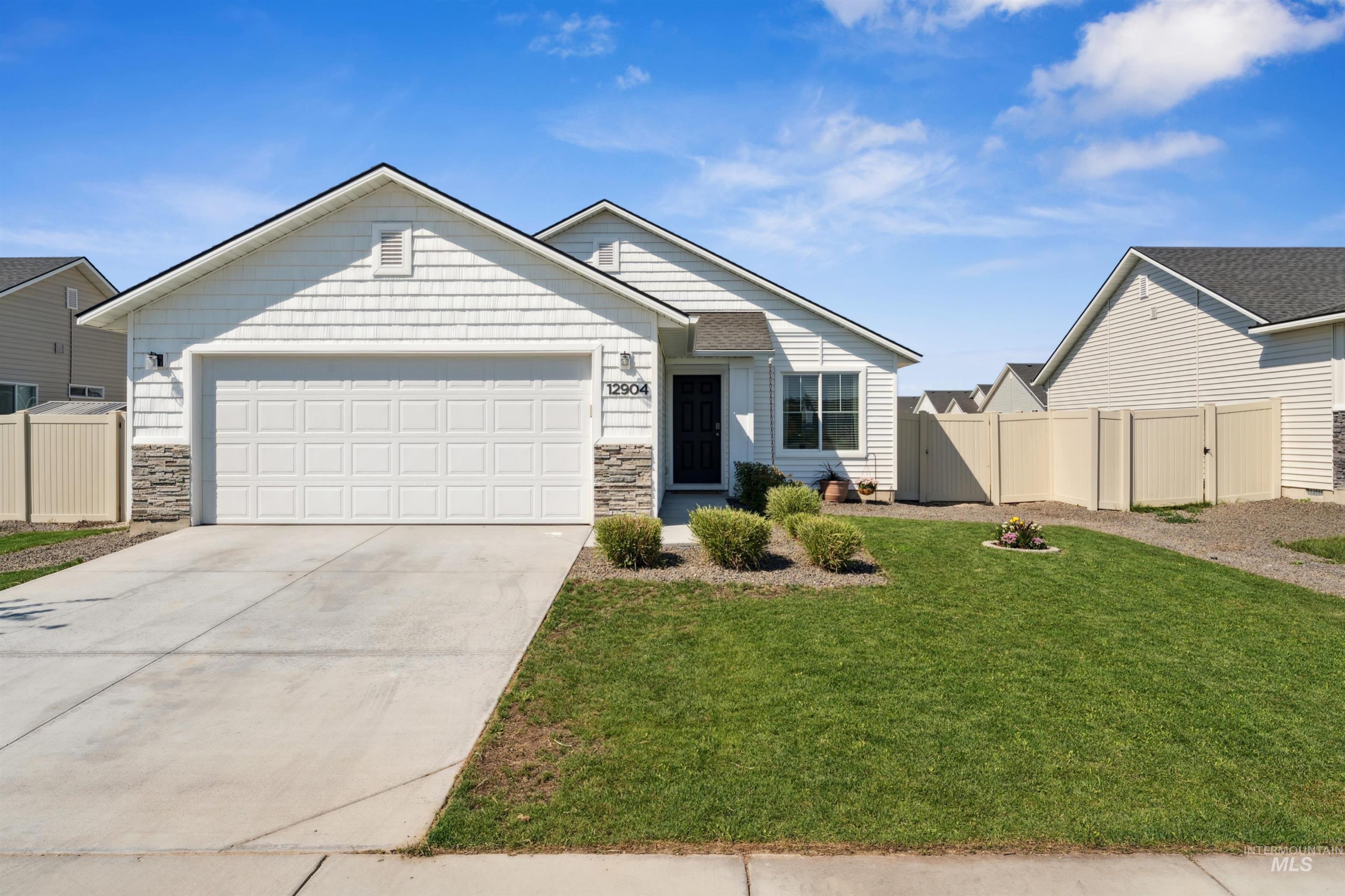 12904 Ashfield Street Caldwell, ID 83607 - Photo 1 of 1 View of front of home with stone siding, a garage, a gate, and concrete driveway