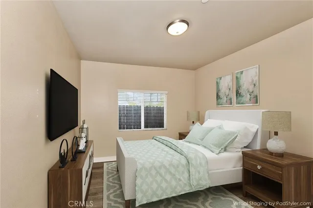 a bedroom with a bed and a flat tv screen on wall