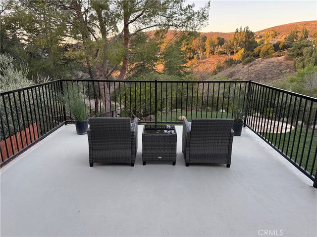 a view of a roof deck with couches and wooden floor