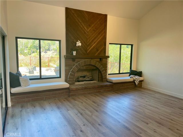 a living room with a fireplace and a floor to ceiling window