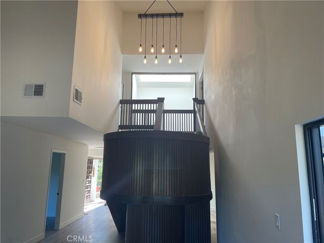 a view of a hallway with windows and chandelier