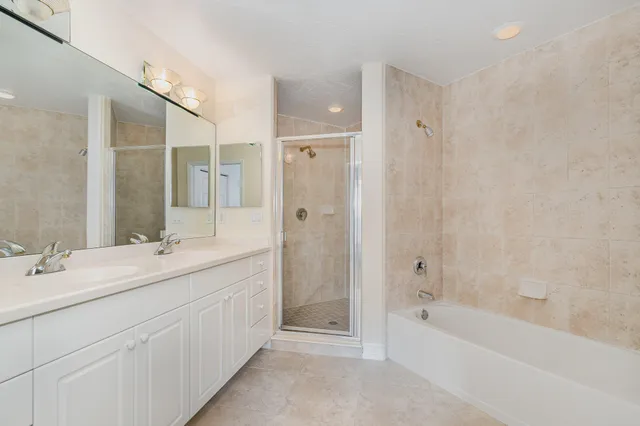 a bathroom with a double vanity sink mirror double and bathtub