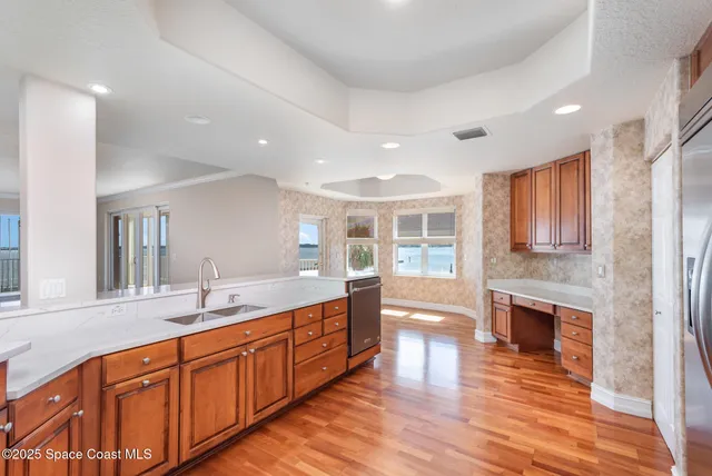 a large kitchen with stainless steel appliances granite countertop a sink and wooden cabinets