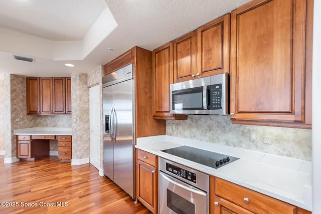 a kitchen with stainless steel appliances granite countertop a stove a sink and a microwave