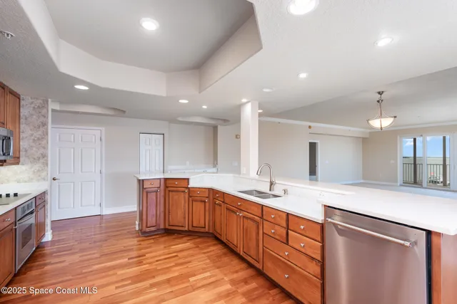 a large kitchen with stainless steel appliances granite countertop a sink and dishwasher with wooden floor