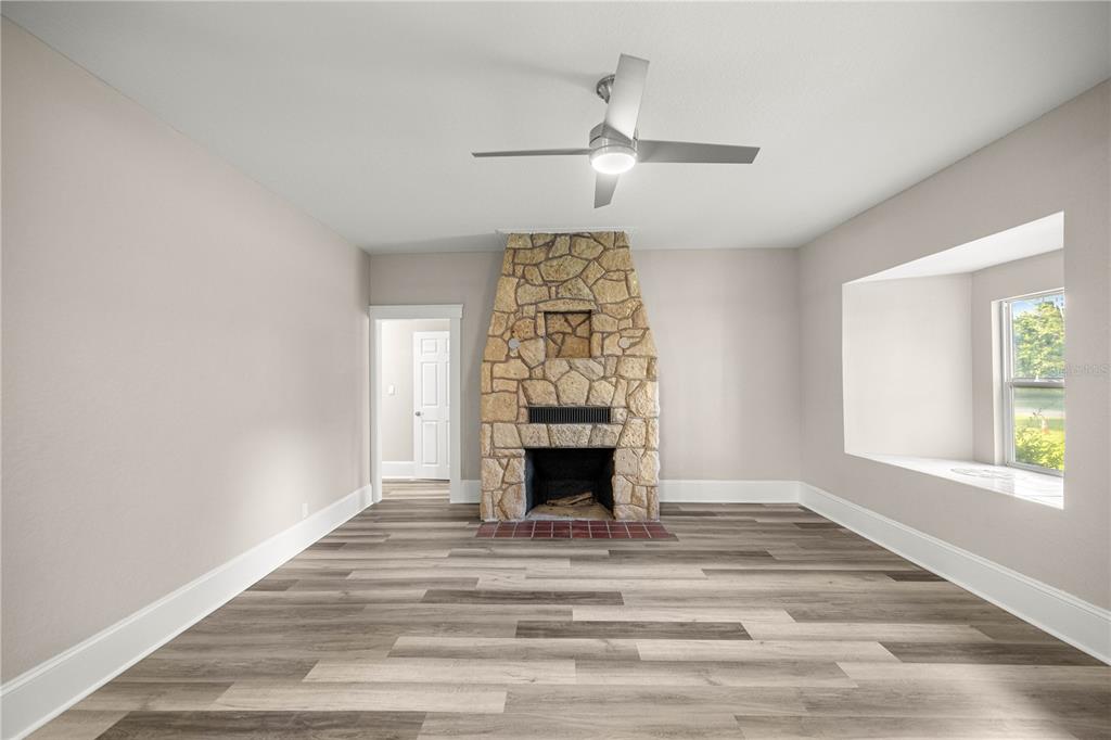 4609 Northeast 7th Street Ocala, FL 34470 - Photo 16 of 36 wooden floor fireplace and windows in an empty room