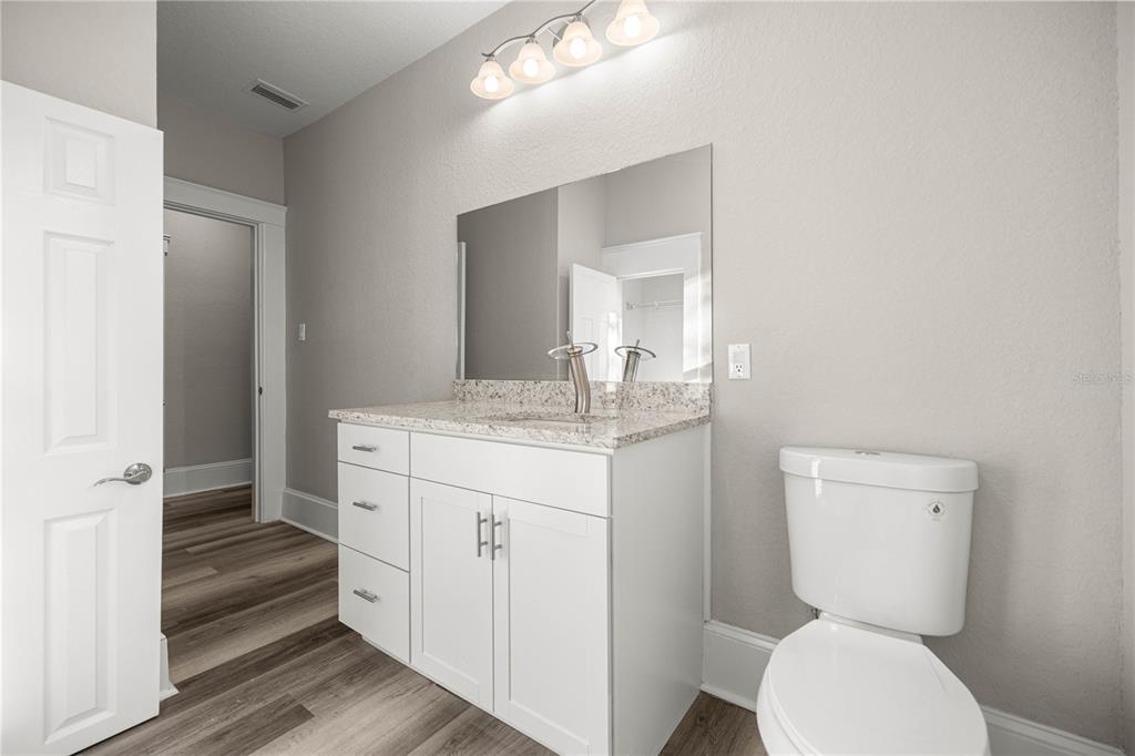 4609 Northeast 7th Street Ocala, FL 34470 - Photo 20 of 36 a bathroom with a granite countertop toilet sink and mirror