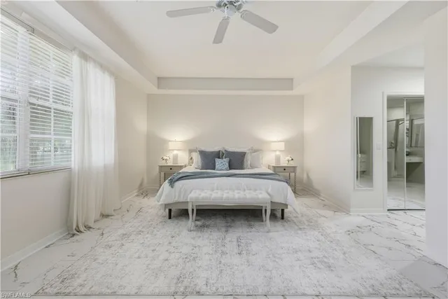 a bedroom with a bed and a chandelier fan