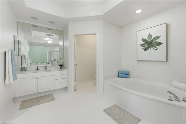 a bathroom with a granite countertop sink a mirror a bathtub and shower