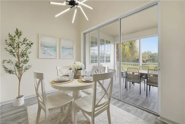 a dining room with furniture a chandelier and wooden floor