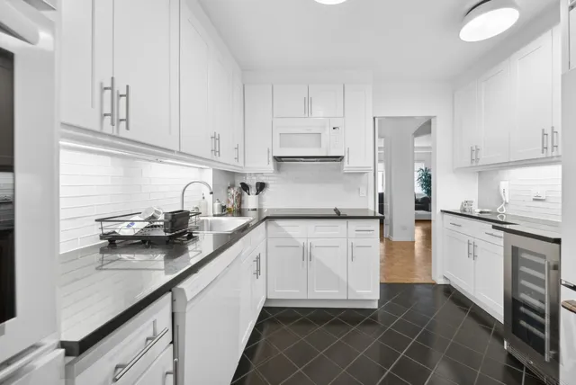 a kitchen with stainless steel appliances granite countertop a sink stove refrigerator and cabinets