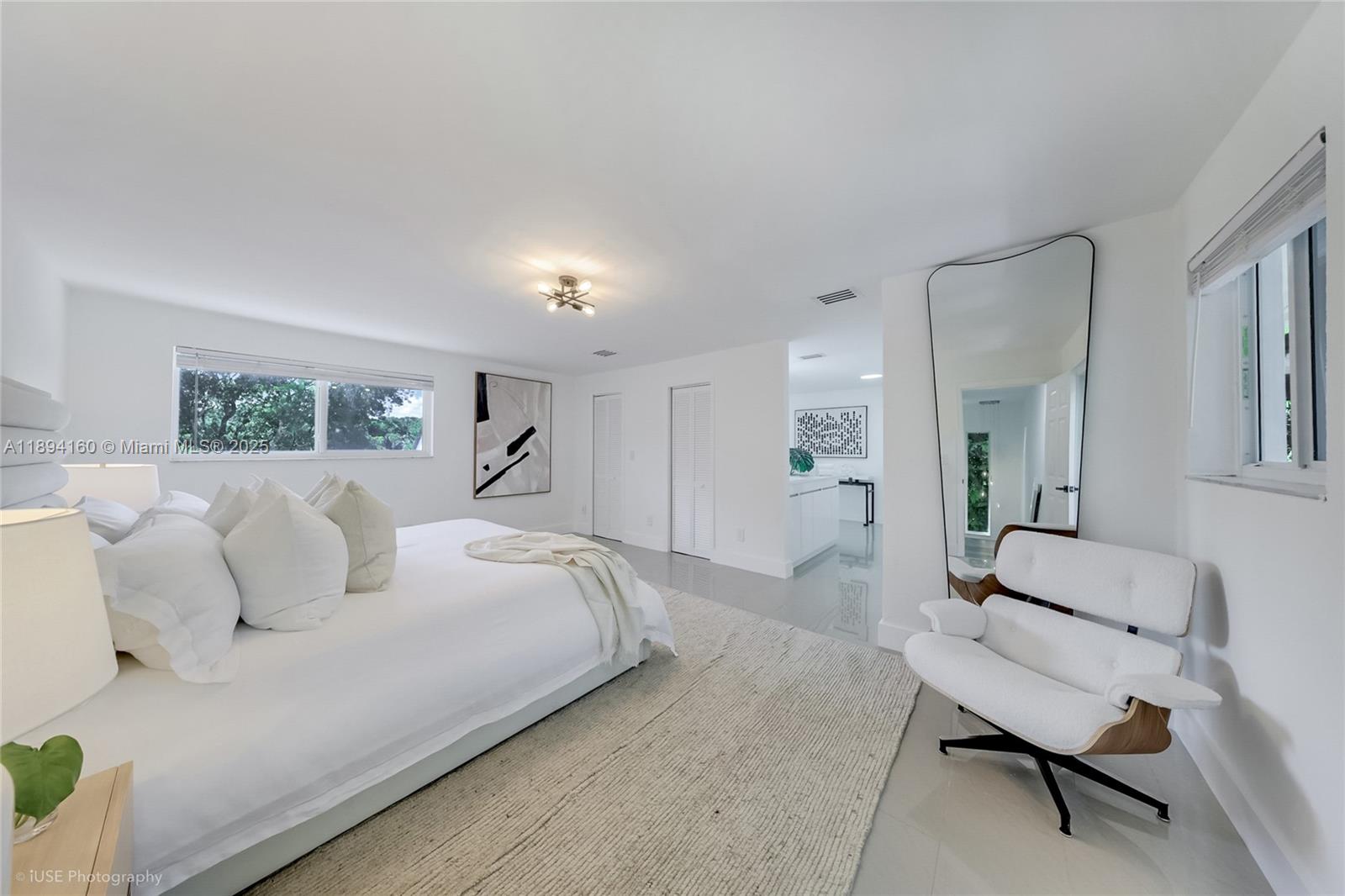 871 Northeast 81st Street Miami, FL 33138 - Photo 18 of 42 a spacious bedroom with a bed a couch and a view of en suite bathroom