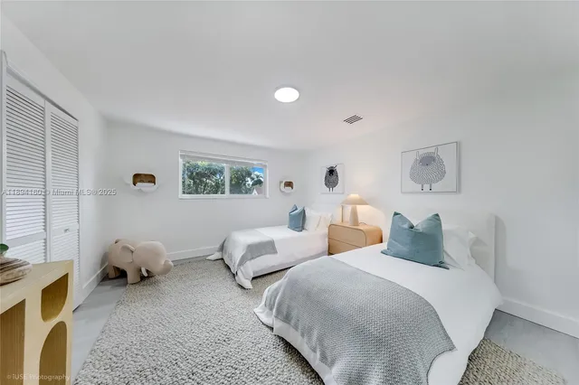 a bedroom with two beds and a window