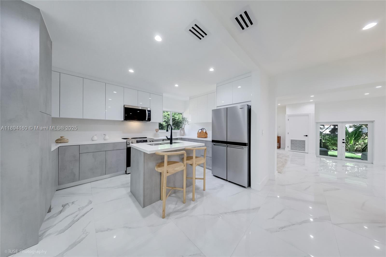 871 Northeast 81st Street Miami, FL 33138 - Photo 9 of 42 a kitchen with white cabinets and stainless steel appliances