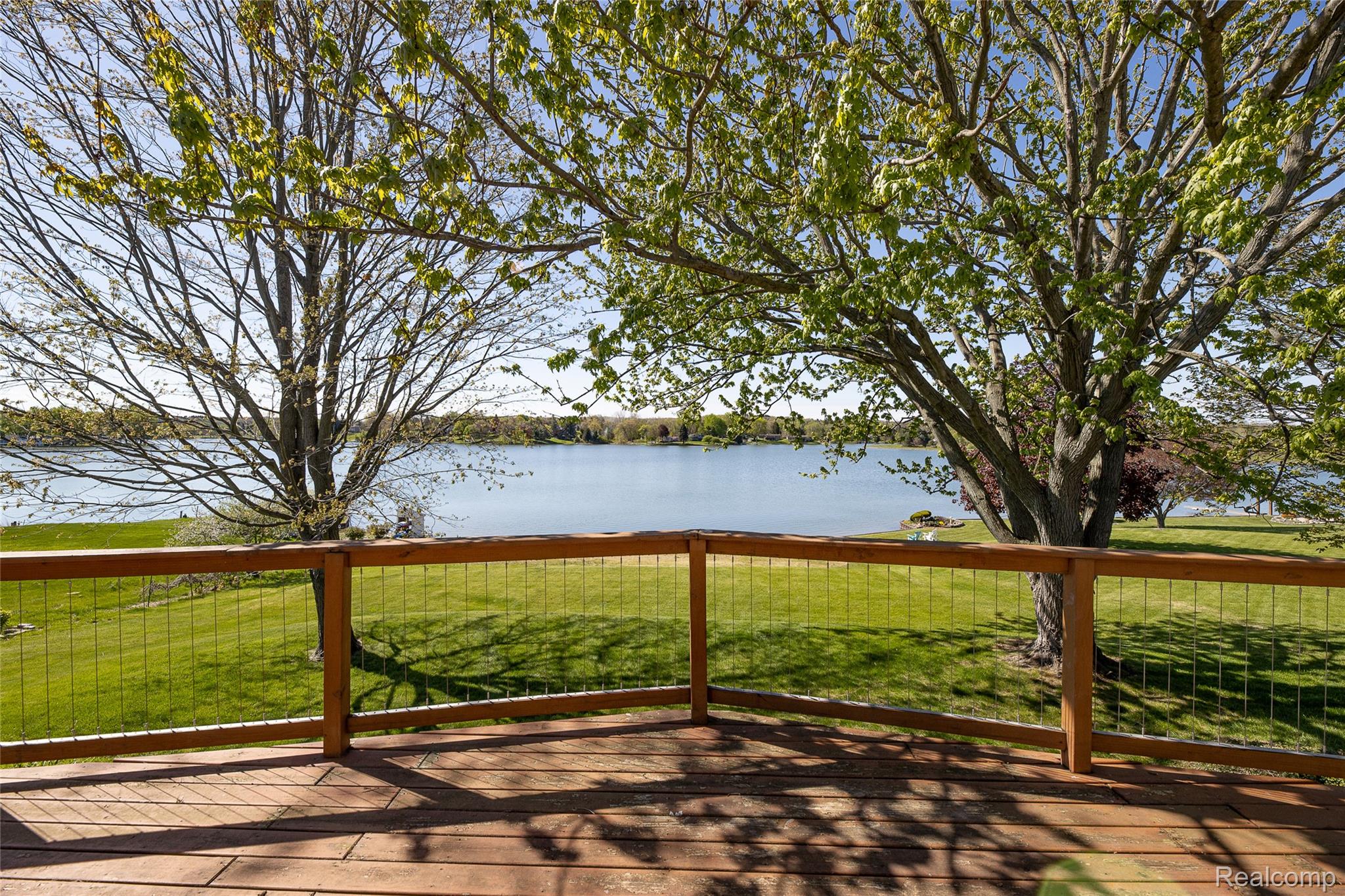 2855 Farmers Creek Road Metamora, MI 48455 - Photo 6 of 51 Expansive wooden deck with wire railing overlooking a tranquil body of water