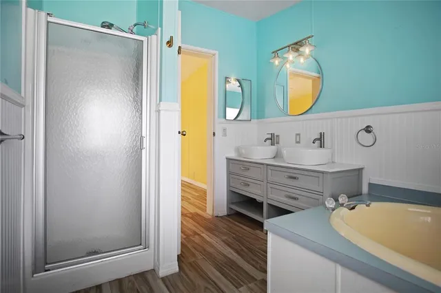 a bathroom with a tub sink and mirror