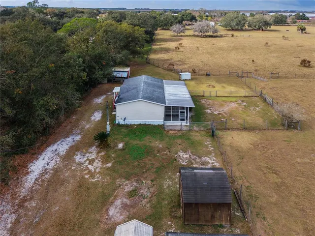 a aerial view of a house with a yard and lake view