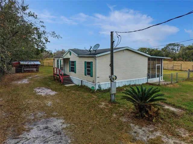 a view of a house with a backyard and a patio
