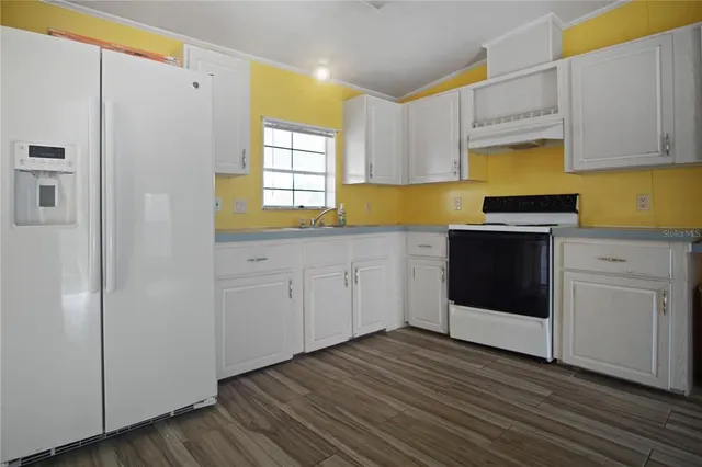 a kitchen with stainless steel appliances a white cabinets and sink