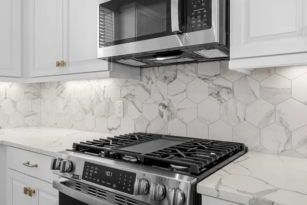 a stove top oven sitting inside of a kitchen