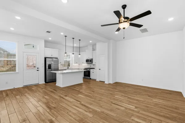 a view of kitchen with refrigerator and microwave