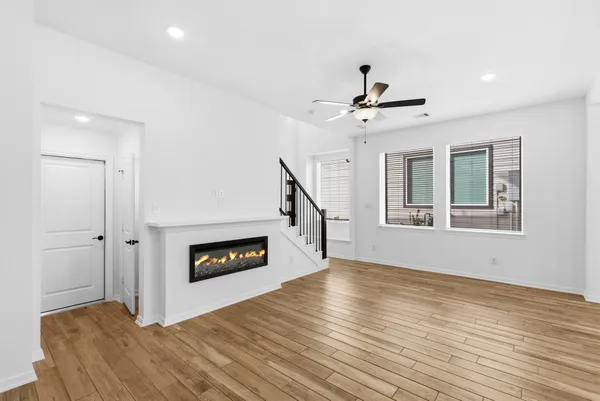 a view of an empty room with window and wooden floor