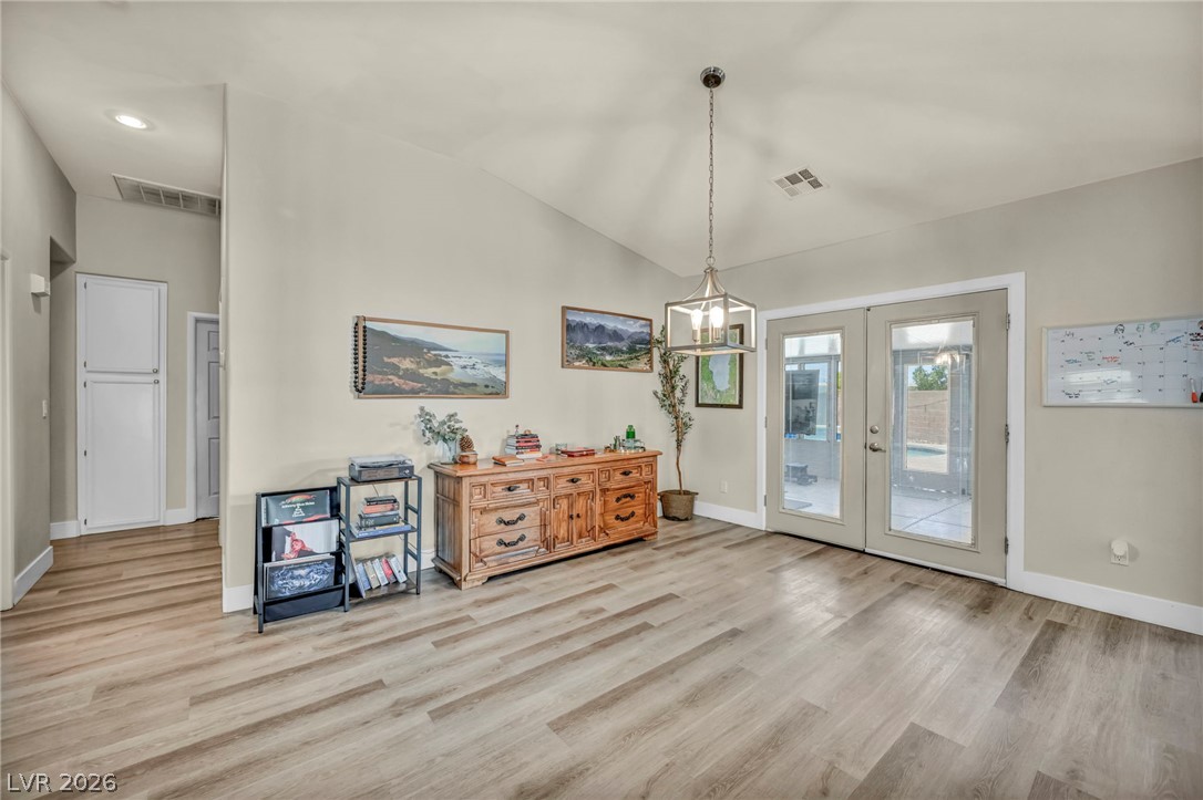 1234 Sunfire Street Henderson, NV 89014 - Photo 7 of 40 Laminated flooring and a vaulted ceiling complement the dining area with outdoor access.