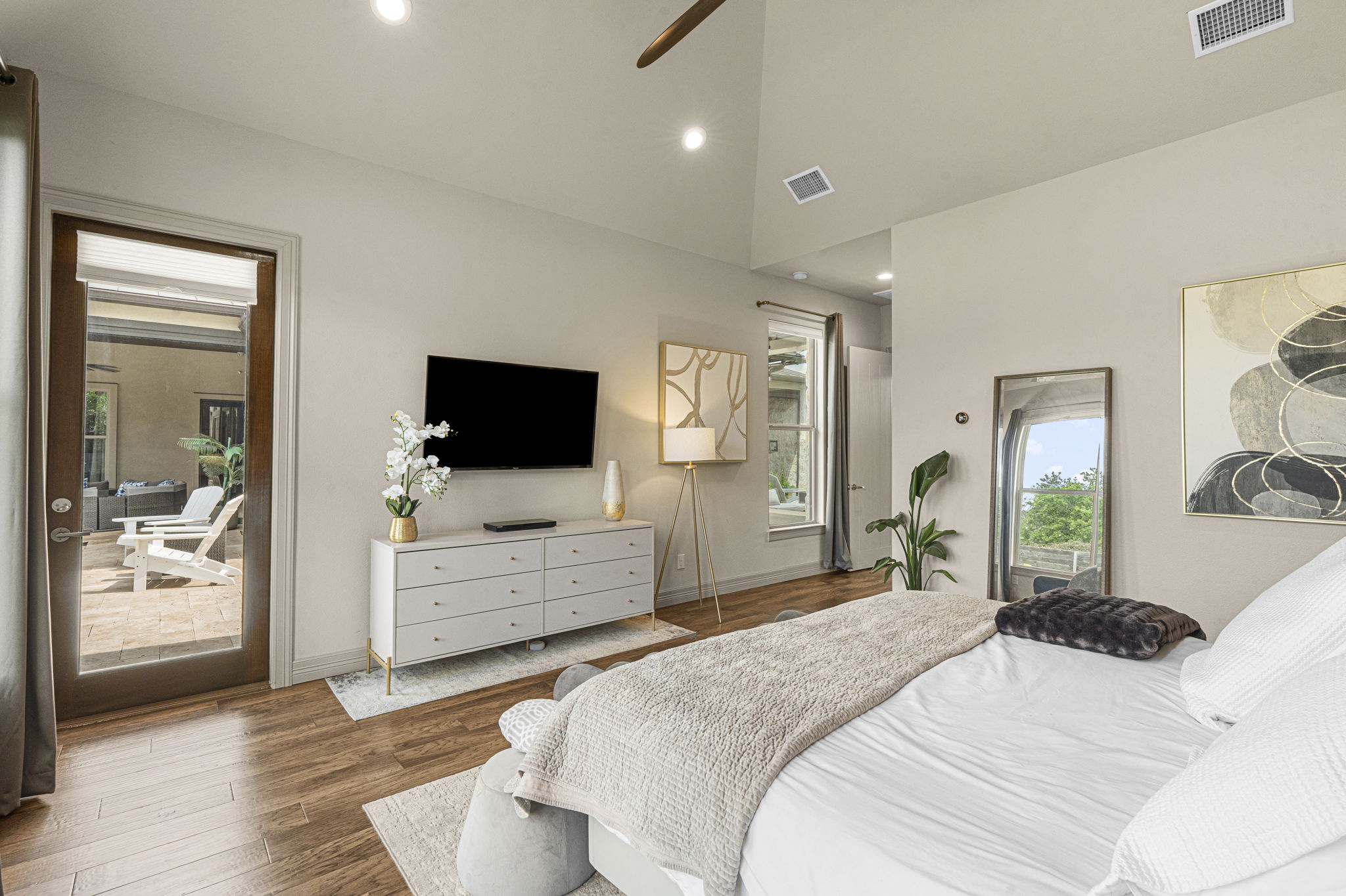 16202 Remuda Trail Buda, TX 78610 - Photo 12 of 40 Primary bedroom features hardwood floors, a vaulted ceiling, and a full-light door providing direct access to an outdoor patio area