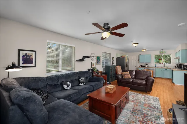 a living room with furniture ceiling fan and a window