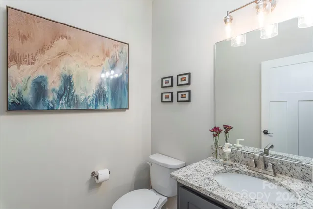 a bathroom with a granite countertop sink mirror and toilet