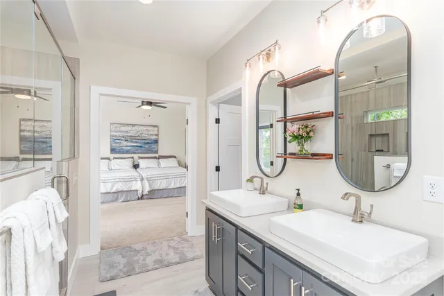 a en suite bathroom with a granite countertop double vanity sink and a mirror