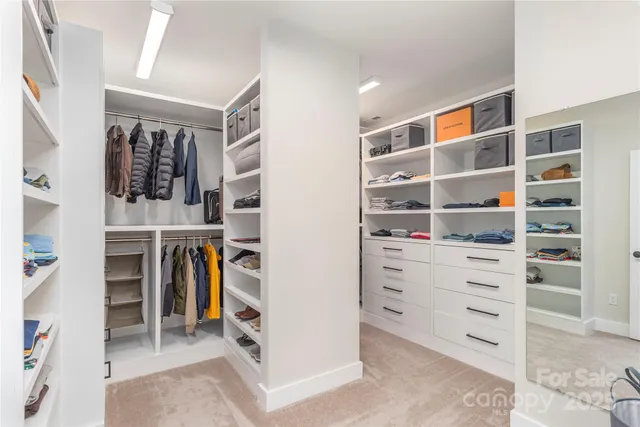 a view of walk in closet with clothes and shoes