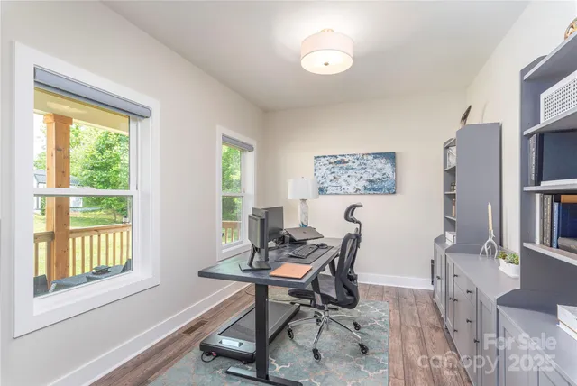 a view of a workspace with furniture and a window