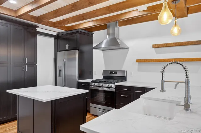 a kitchen with stainless steel appliances a stove refrigerator and sink