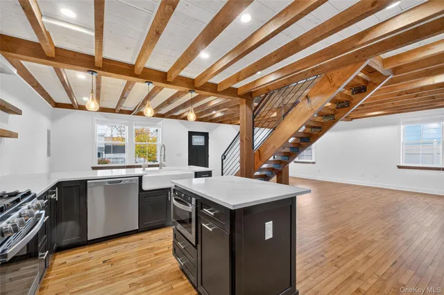 a kitchen with a sink a stove cabinets and wooden floor