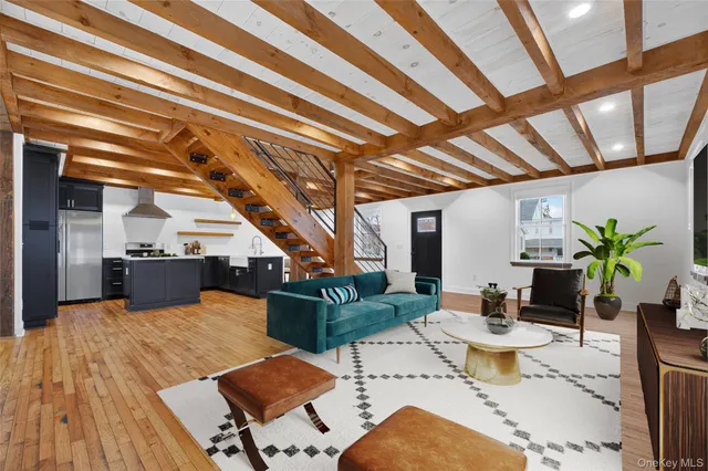 a view of a dining room with furniture a rug and wooden floor